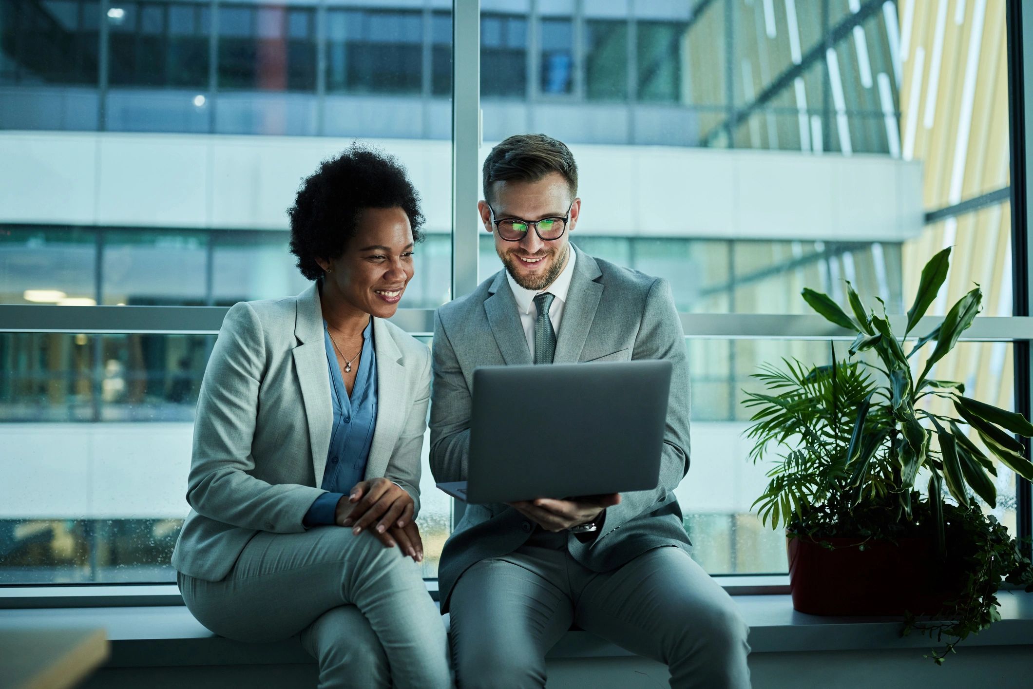 Consultants collaborating over a laptop in an office